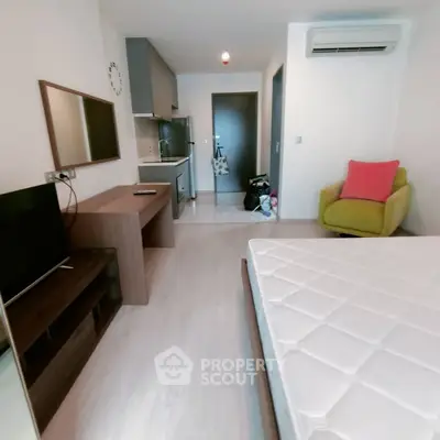 Modern studio apartment with compact kitchen and cozy living area, ideal for urban living.