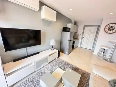 Modern living room with sleek furniture and open kitchen layout in stylish apartment.