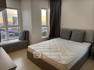 Modern bedroom with city view, featuring a cozy bed and large windows for natural light.