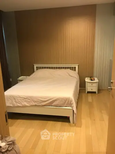 Cozy bedroom with wooden flooring and modern decor, perfect for relaxation.