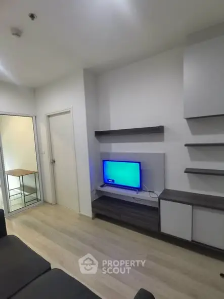 Modern living room with sleek shelves and TV unit, featuring minimalist design and light wood flooring.