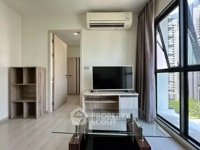 Modern living room with glass table, TV, and large windows offering city views.