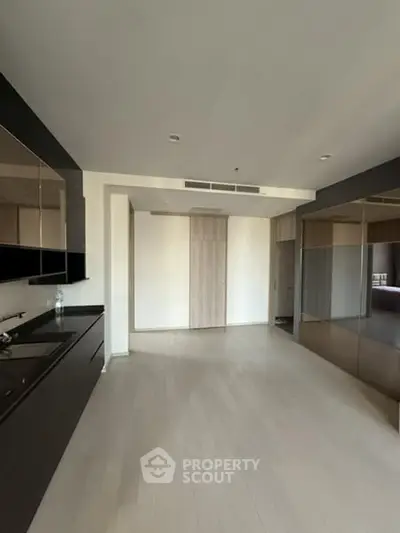 Modern kitchen with sleek black cabinets and open layout in a contemporary apartment.