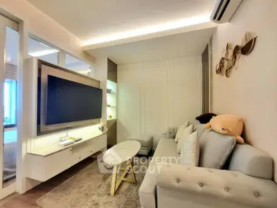 Modern living room with cozy sofa, wall-mounted TV, and stylish decor in a bright apartment.