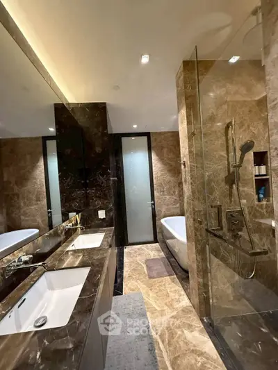 Luxurious marble bathroom with dual sinks and glass shower enclosure