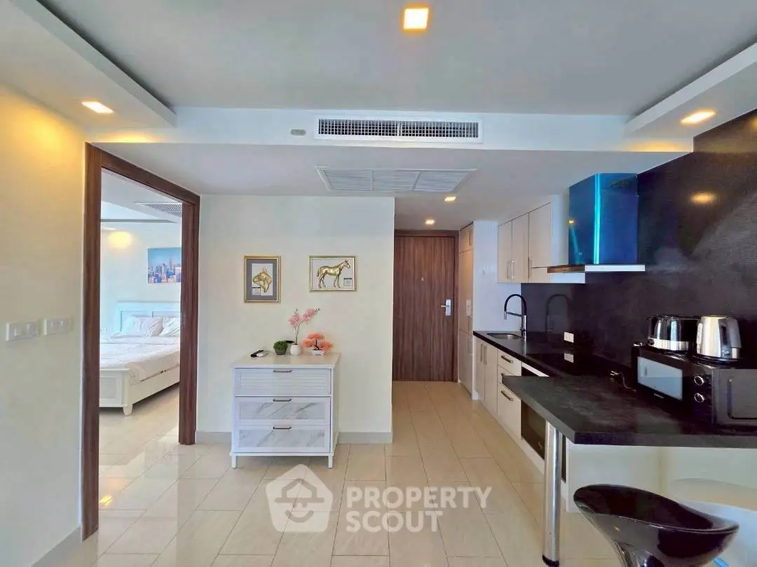 Modern open-layout kitchen with sleek appliances and adjacent bedroom view.