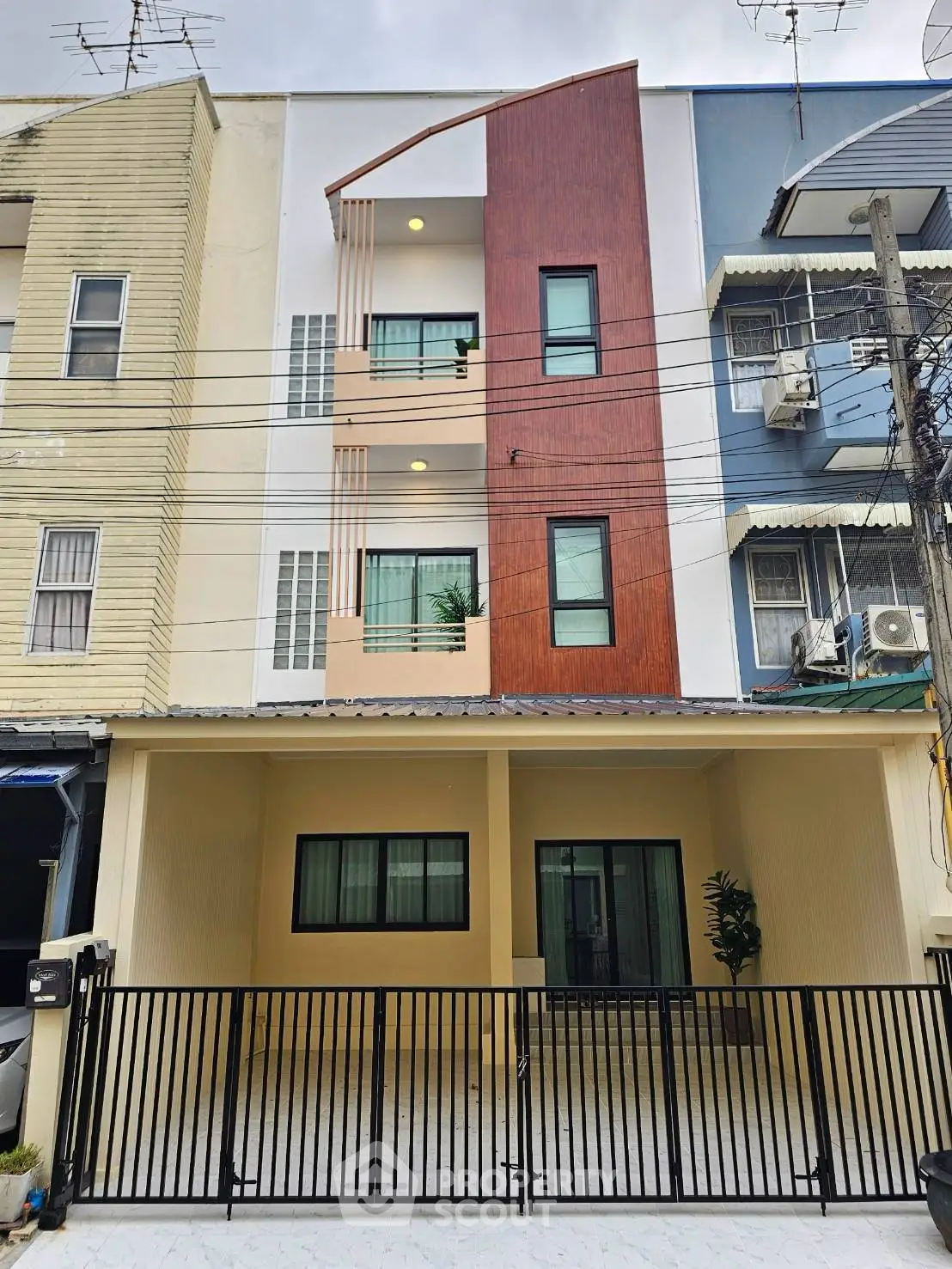 Modern townhouse exterior with unique facade design and gated entrance, perfect for urban living.