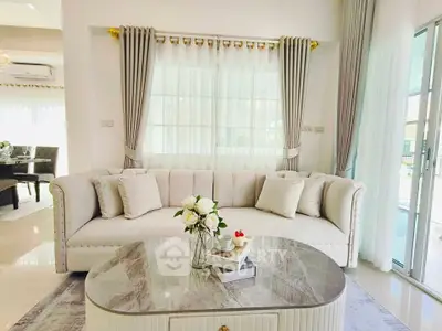Elegant living room with plush sofa and marble coffee table in a bright, airy space.