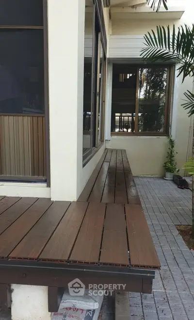 Charming exterior patio with wooden decking and lush greenery, perfect for relaxation and outdoor gatherings.
