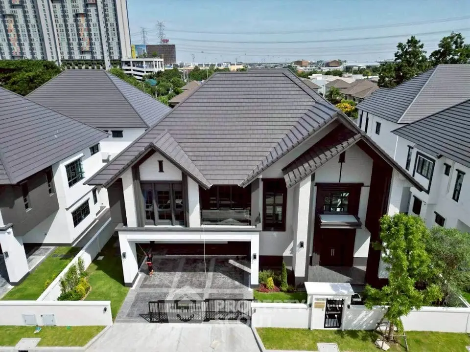 Luxurious modern house with sleek design and spacious driveway in upscale neighborhood.