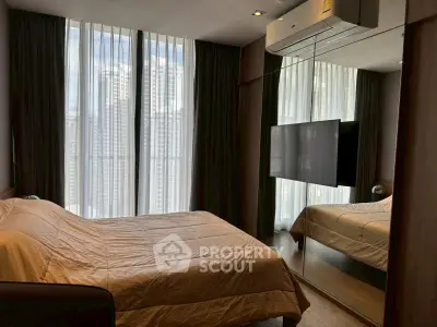 Modern bedroom with mirrored wall and large window in luxury apartment