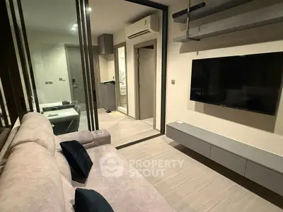 Modern living room with sleek design and wall-mounted TV in a cozy apartment.