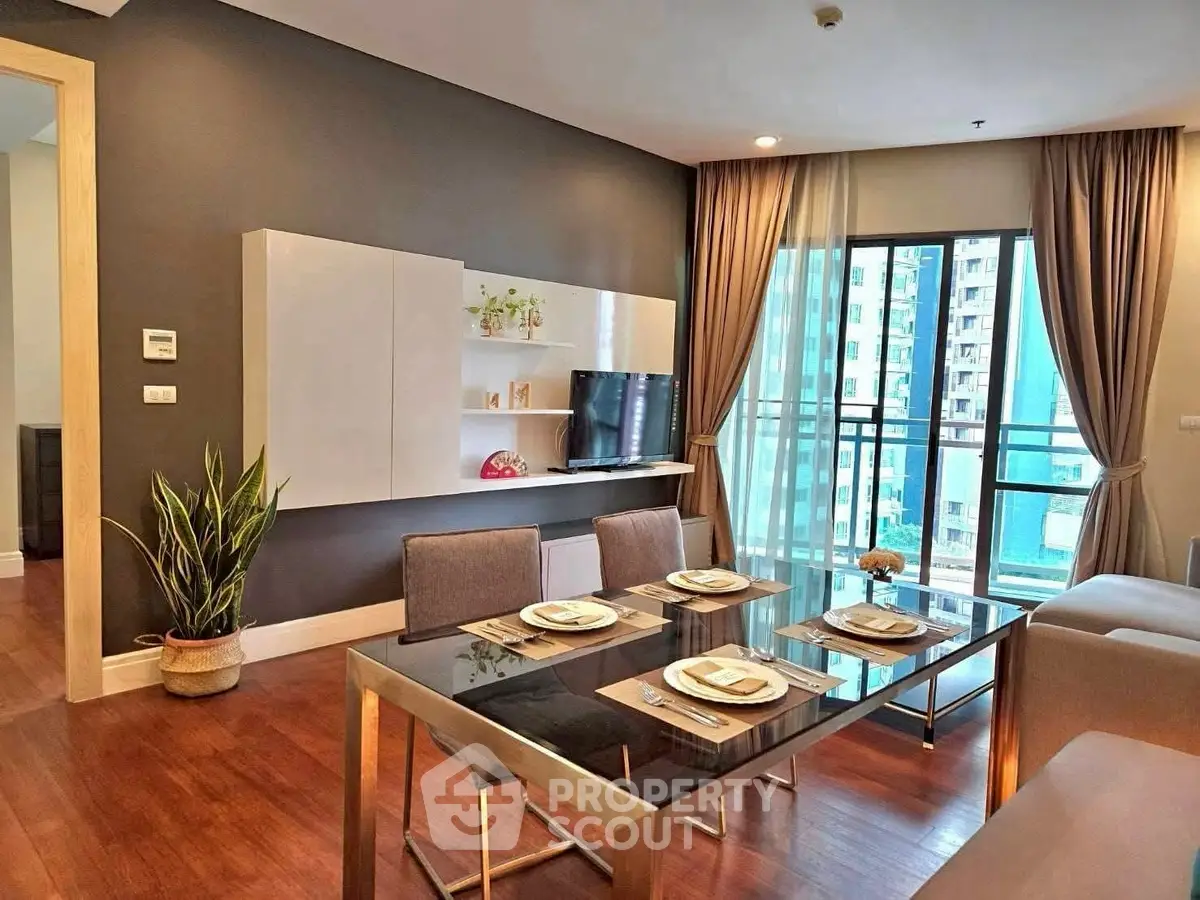 Modern living room with dining area and city view, featuring sleek furniture and elegant decor.