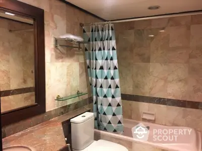 Luxurious marble bathroom with modern shower curtain and elegant fixtures.