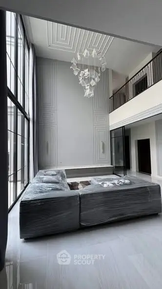 Luxurious modern living room with high ceilings and elegant chandelier