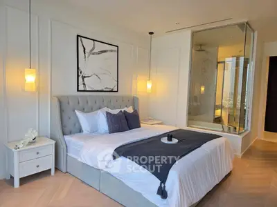 Luxurious bedroom with modern decor and glass wall bathroom view