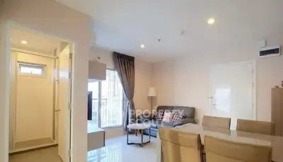 Modern living room with cozy sofa and dining area, bright natural light.