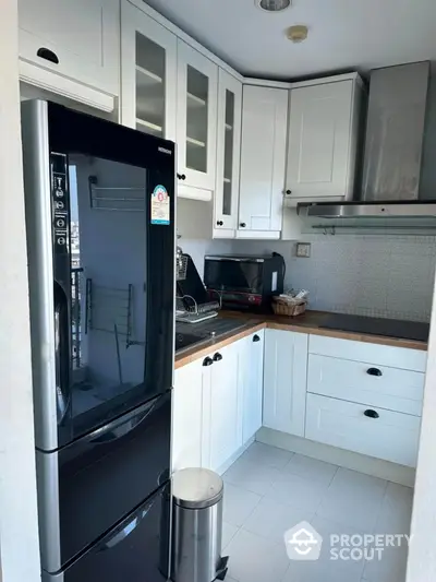 Modern kitchen with sleek black fridge and white cabinets