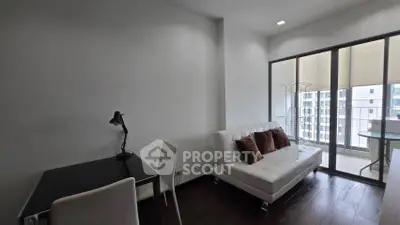Modern living room with sleek furniture and balcony view in urban apartment.