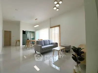 Spacious modern living room with sleek furniture and abundant natural light.