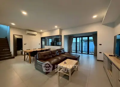 Spacious modern living room with leather sofa and large windows