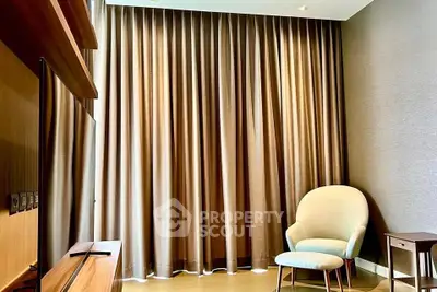 Elegant living room with floor-to-ceiling curtains and modern armchair, perfect for relaxation.