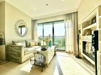 Bright and elegant living room with large windows and stylish decor, offering a serene view.