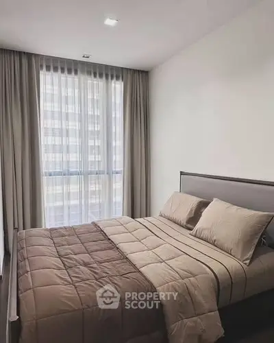 Modern bedroom with large window and elegant curtains in a stylish apartment.