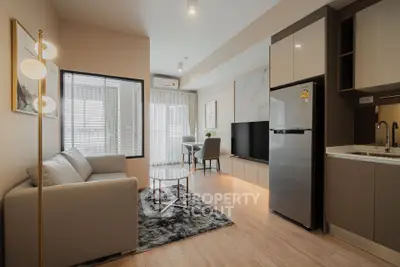 Modern living room with sleek furniture and open kitchen in a stylish apartment.