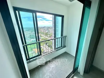 Modern apartment balcony with stunning city view and glass sliding doors.
