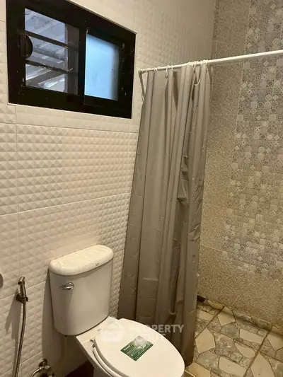 Modern bathroom with textured tiles and shower curtain in a stylish home.
