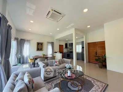 Spacious living room with modern decor and open layout, featuring cozy seating and natural light.