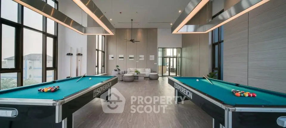 Luxurious recreation room with pool tables and modern seating area in upscale building.