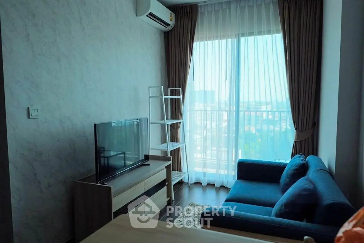 Cozy living room with blue sofa, TV, and large window with city view.