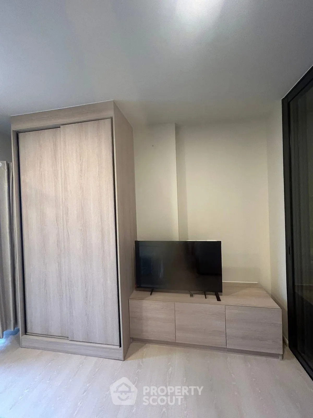 Modern living room with sleek wooden furniture and flat-screen TV
