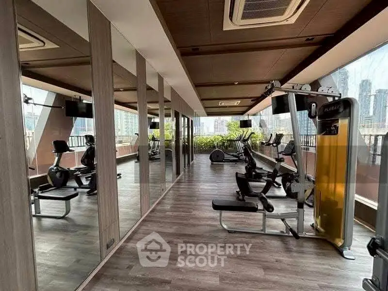 Modern gym with city view and state-of-the-art equipment in luxury building.