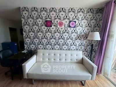 Stylish living room with modern white sofa and floral wallpaper, accented by purple curtains and decor.