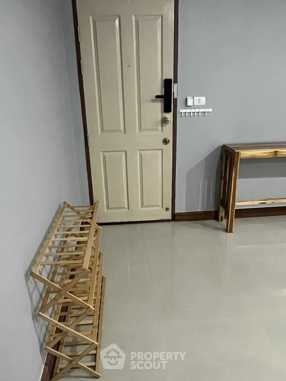 Minimalist entryway with wooden shoe rack and console table