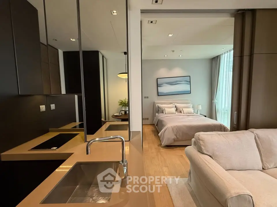 Modern open-plan living room and bedroom with sleek kitchen design in luxury apartment.