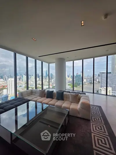Luxurious living room with panoramic city skyline views and modern furnishings.