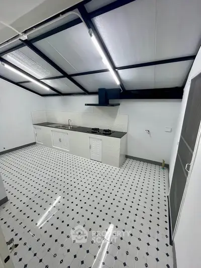 Spacious kitchen with modern gas stove and sleek tiled flooring in a contemporary home.