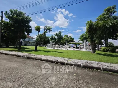 Spacious outdoor garden area with lush greenery and clear blue sky, perfect for relaxation and leisure activities.