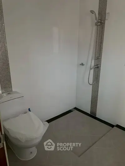 Modern bathroom with sleek shower and toilet in minimalist design