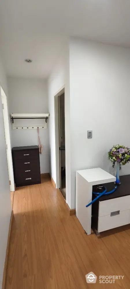 Charming hallway with wooden flooring and modern decor in a cozy apartment.