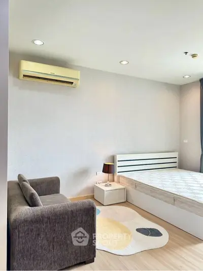 Modern bedroom with air conditioning and cozy sofa, perfect for relaxation.