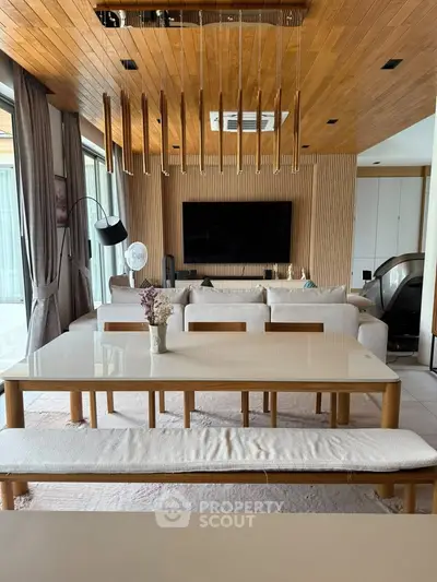 Luxurious modern living room with elegant wooden ceiling and spacious dining area.