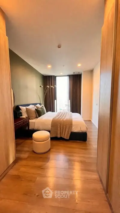 Luxurious bedroom with modern decor and large window offering natural light.