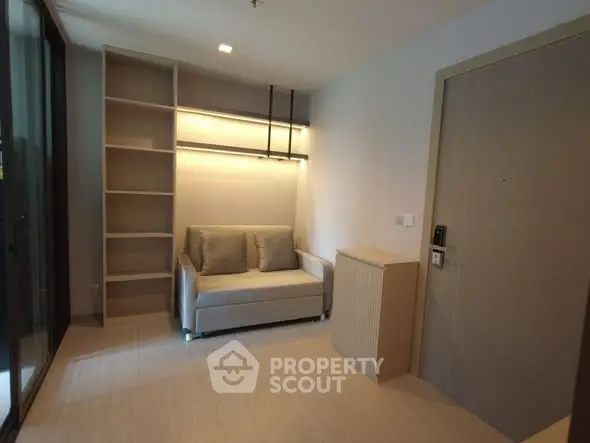Modern living room with sleek sofa and built-in shelves in a cozy apartment.