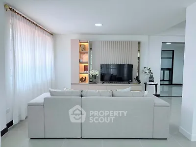 Spacious modern living room with elegant decor and large sofa, perfect for relaxation and entertainment.
