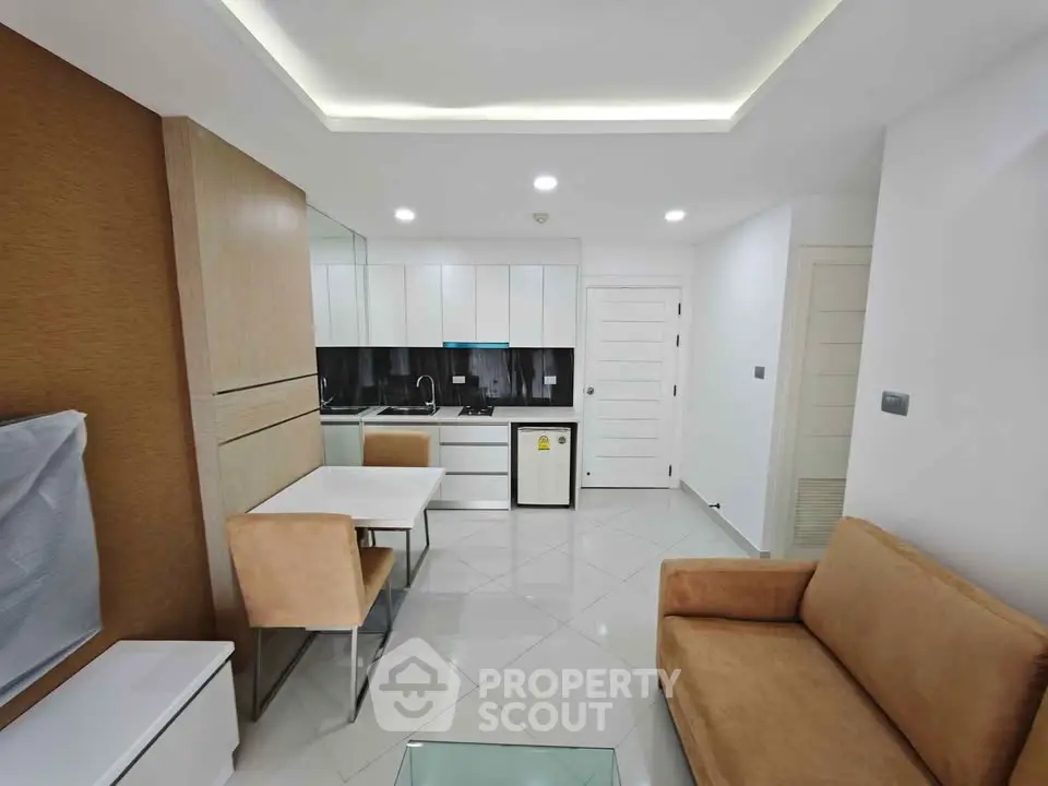 Modern living room with sleek kitchen and cozy seating area in a stylish apartment.